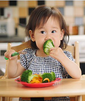 Alimentation prévention fruits légumes - Aprifel Enfant mangeant un brocoli
