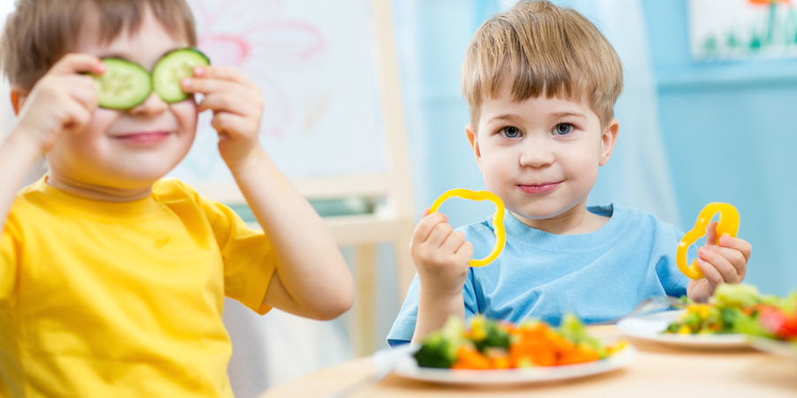 Deux petits garçons croquant dans des légumes