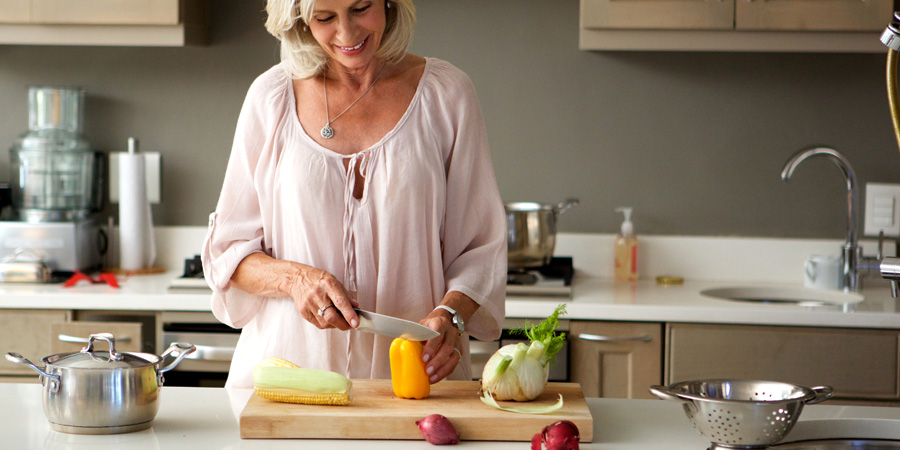 Femme senior qui cuisine des fruits et légumes