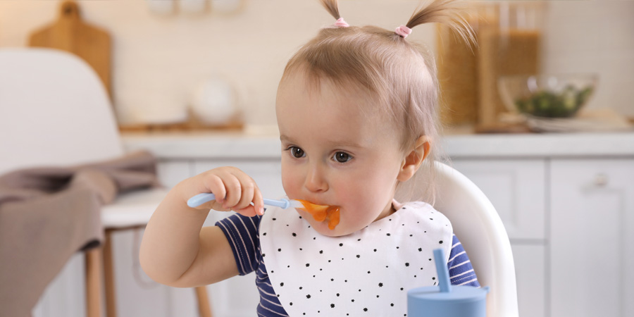petite fille qui mange purée chaise haute