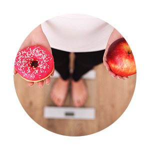 femme sur balance pomme et beignet choix