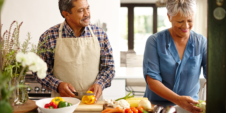 senior couple cooking vegetables