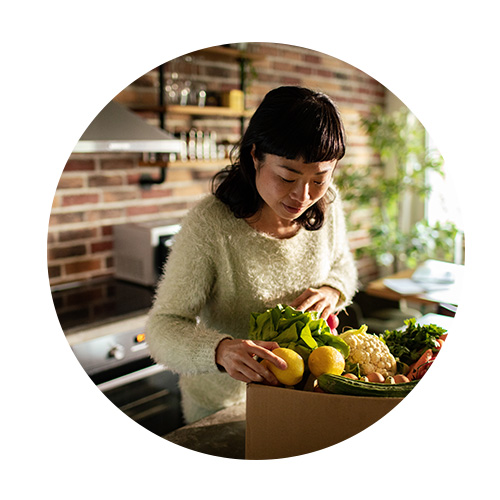 Femme regardant des légumes territorialisation de l'alimentation - Aprifel